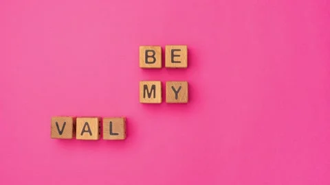 Stop-motion wooden cubes with the phrase Be My Valentine on an empty colorful Stock Footage 232135825