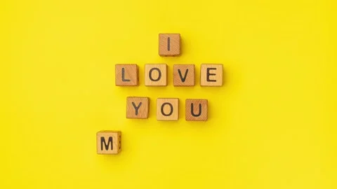 Stop-motion wooden cubes with the phrase I Love You Maybe on an empty colorful Stock Footage 232254853