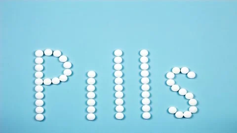 Stop motion word text letters pills on blue background 4K. Stock Footage 155218265