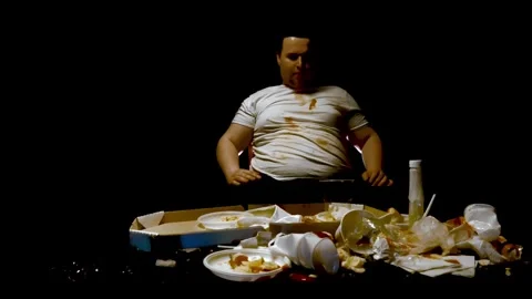 Stop overeating, go on a diet concept. Fat plump guy swipes all fast food off Stock Footage 260797162