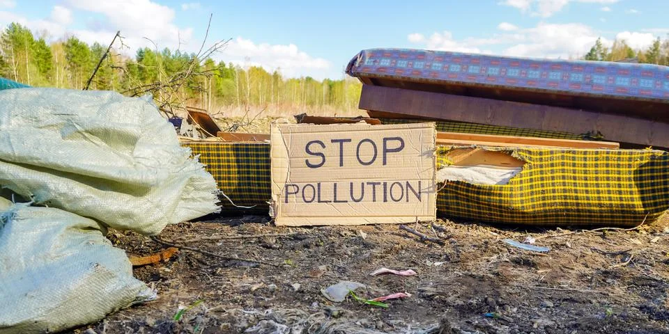 Stop pollution sign in illegal dumping site Stock Photos