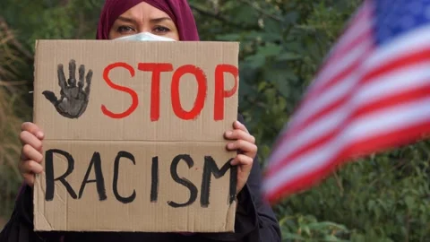 Stop racism slogan. Arab immigrant Muslim woman. BLM Stock Footage 135428910