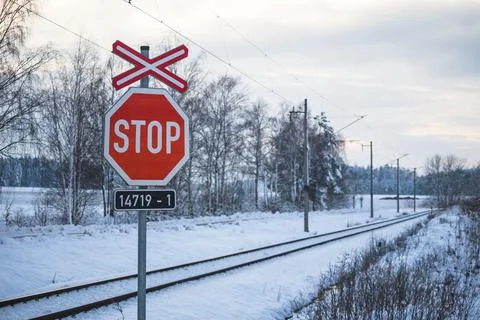 STOP road sign, at a railway, in a winter snowy landscape Stock Photos