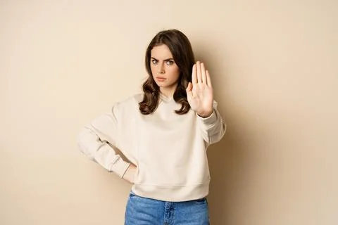 Stop. Serious and confident woman showing extended arm palm, prohibit, forbid Stock Photos