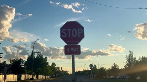 Stop sign 4 way intersection with sky clouds summer evening Stock Footage 341858115