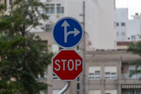 Stop Sign And Direction Arrow Road Sign In Urban Street Close Up Stock-Fotos