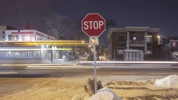 A Stop Sign Centered in front of City Night Traffic Stock Footage 85574122