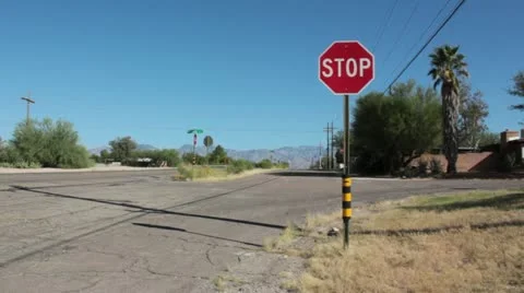 Stop Sign on Side Road as Traffic Moves By Stock Footage 12177249