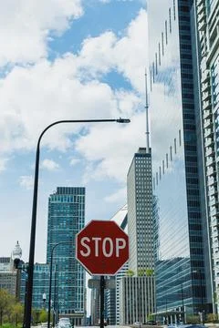 Stop sign stands at an intersection in a modern city with tall buildings an.. Stock Photos