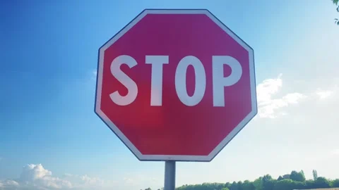 Stop signal with cloudy blue sky in background 스톡 동영상 245072495