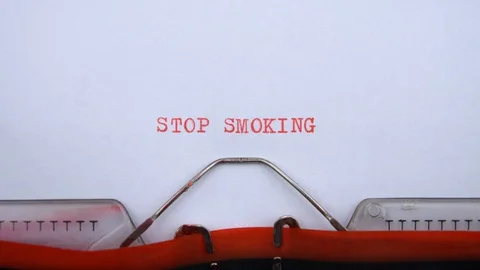 Stop smoking - phrase printed on an old typewriter in red letters, close up. Video stock 128399895