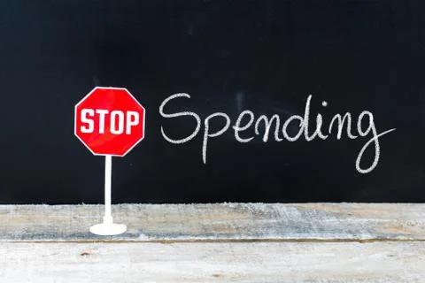 STOP SPENDING message written on chalkboard Stock Photos