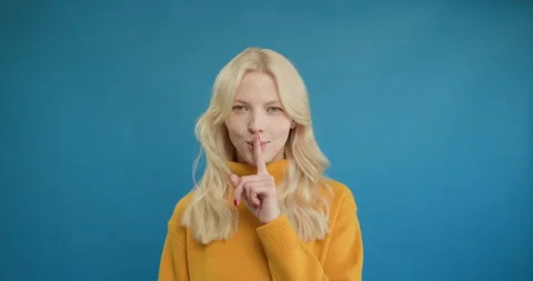 Stop talking. Dissatisfied strict young blonde woman making quiet gesture Stock Footage 150907015