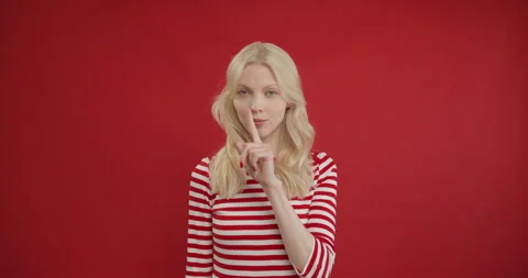 Stop talking. Dissatisfied strict young blonde woman making quiet gesture Stock Footage 150907236