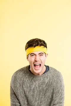 Stop telling me what to do. a handsome young man sitting alone in the studio and Stock Photos