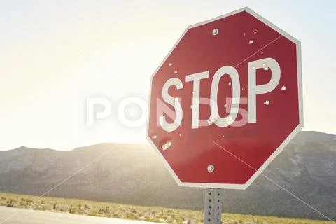 Stop Traffic Sign With Bullet Holes On Country Road Stock Photos