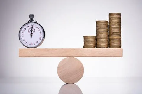 Stop Watch And Stack Of Coins On Scale 库存照片