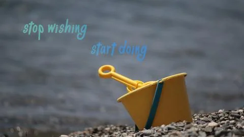 Stop wishing, start doing sentence. Toy bucket shovel on the beach Stock Photos