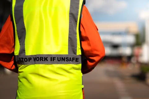 "Stop work if unsafe" on lifting reflective vest. Stock Photos