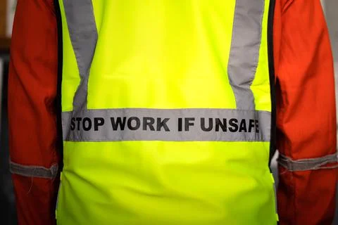 "Stop work if unsafe" on lifting reflective vest. Stock Photos