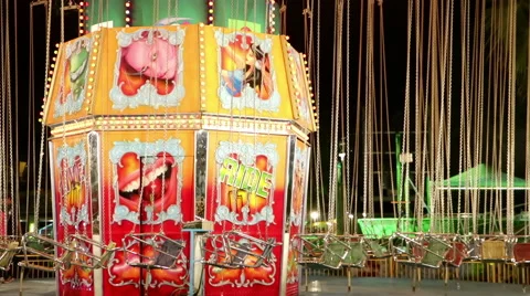 Stopped funfair night lit carousel with hanging seats on chains  Vidéo 64198590