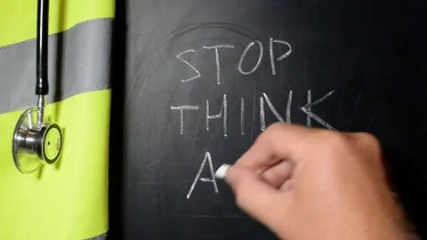 Stop,Think, Act written on a chalk board by a safety officer Stock Footage 81416872