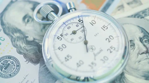 Stopwatch dial over the and dollar banknotes. Financial money concept Stock Footage 156301193