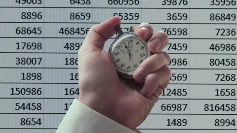 Stopwatch in a hand against screen with numbers Видео 235156268