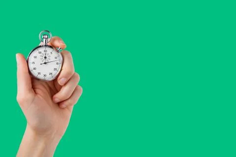 Stopwatch hold in hand, button pressed, green background Stock Photos
