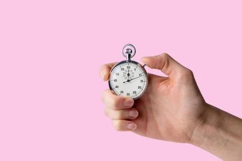 Stopwatch hold in hand, button pressed,  pink background Stock Photos