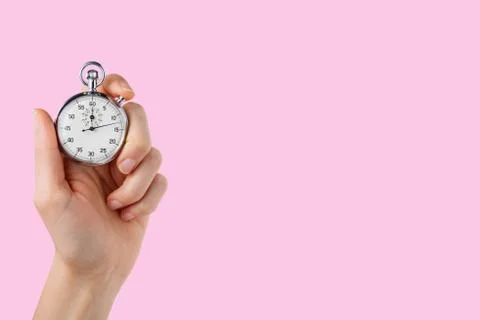 Stopwatch hold in hand, button pressed, pink  background Stock Photos