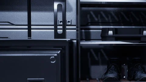 Storage area shows tools and shoes on shelves with dark background Stock Footage 343553155