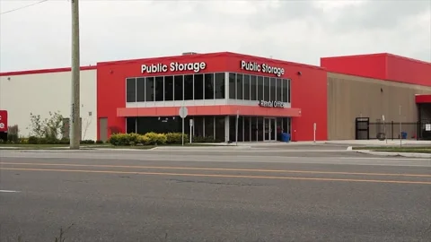 Storage building public storage in white writing on orange background Stock Footage 246611452