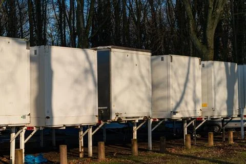 Storage car containers lined up in a forest area during sunset Stock-Fotos