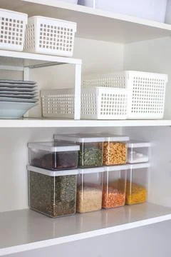 Storage ideas in the kitchen. White box and basket. Shelf order system. Stock Photos