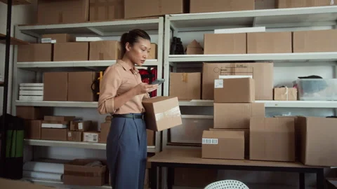 Storage Office Manager Using Phone when Working with Parcels Stock Footage 281718318