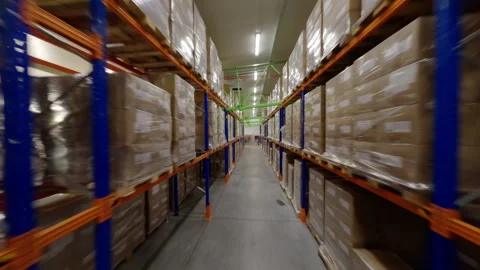 Storage racks in spacious warehouse accommodating cardboard products Видео 290565085