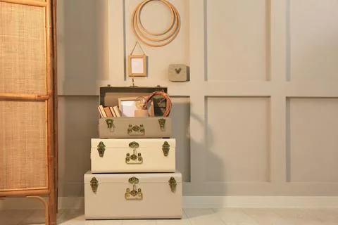 Storage trunks with different decor elements near light wall indoors, space f Stock Photos