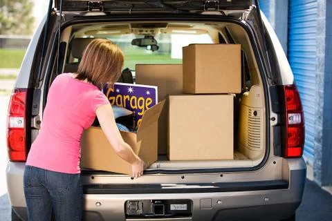 Storage: woman packing away garage sale leftovers Stock Photos