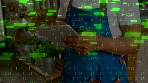 Store associate tapping tablet screen and creating floating green binary code Video stock 310728206