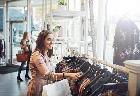 This store is definitely the best in town. a young woman shopping at a clothing Stock Photos