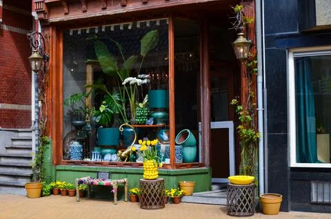 Store with different vintage decor elements and flowers, view from outside Stock Photos