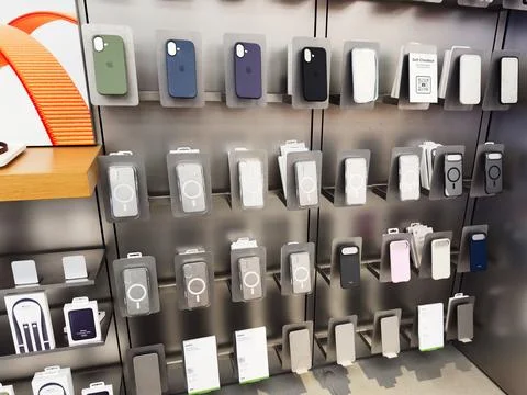 Store display of iPhone phone cases and accessories on metal racks in a tec.. Stock Photos