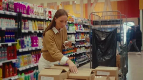 Store employee organizes packages while managing inventory at retail location Stock Footage 293672997