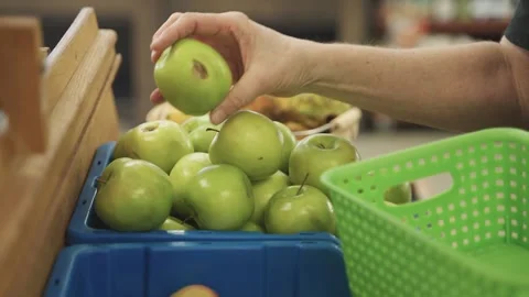 Store employee removing bruised and rotted apples from shelf at grocery store Stock Footage 306134348