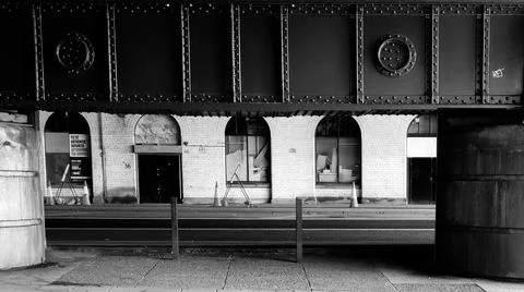 Store front arches viewed from under a railway bridge Stock Photos