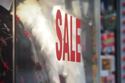 Store front display shows a big sale sign in the window Stock Photos