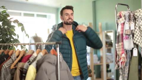 In store, man try on down jacket Stock Footage 329397638