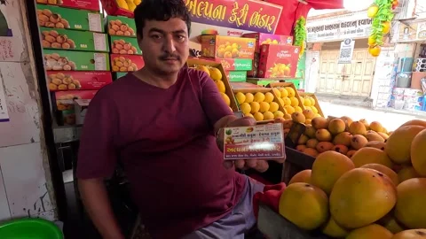 The store manager is showing the visiting card of his mango store Vidéo 274724861