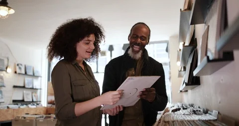 Store owner helping customer in a record store Stock Footage 87533962